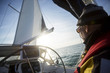 Man Standing At Helm Of Yacht In Sea