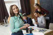 © Diflope - Businesswoman posing while others business people talking in background