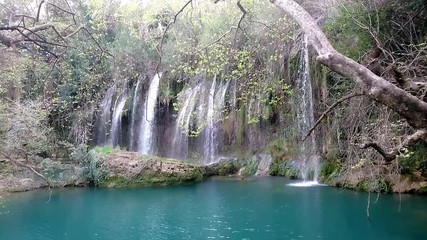 Sticker - View of Kursunlu Waterfall in Antalya, flowing from high, with green trees and plants around.