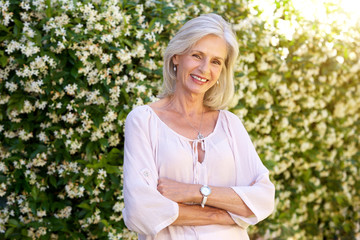 Wall Mural - older woman smiling and standing outside in spring