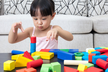 Wall Mural - Asian Chinese little girl playing building blocks at home