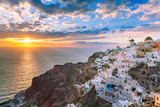 Fototapeta Uliczki - Picturesque view, Old Town of Oia or Ia on the island Santorini, white houses, windmills and church with blue domes at sunset, Greece