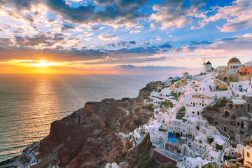 Fototapete - Picturesque view, Old Town of Oia or Ia on the island Santorini, white houses, windmills and church with blue domes at sunset, Greece