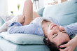 © leszekglasner - Young relaxed woman while lying on comfortable sofa home interior