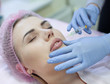 © lashkhidzetim - Woman gets injection in her face. Beauty woman giving injections. Young woman gets beauty facial injections in the cosmetology salon. Face aging injection. Aesthetic Medicine, Cosmetology