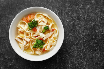 Wall Mural - Chicken noodle soup in bowl on grey background