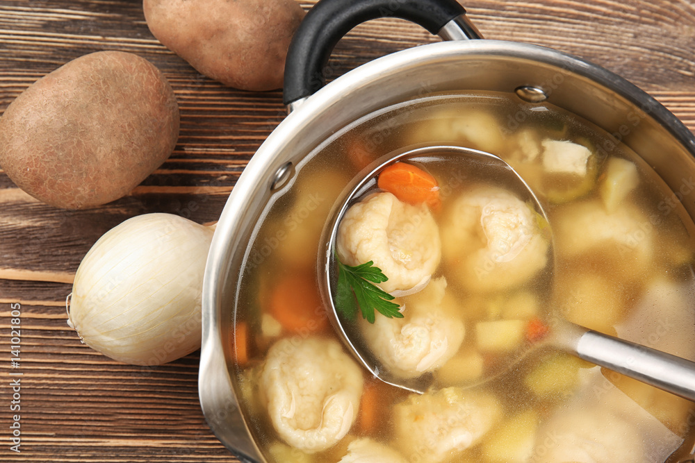 Pan with delicious chicken and dumplings on wooden table