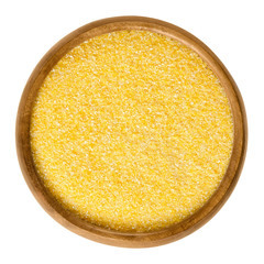 Wall Mural - Cornmeal in wooden bowl. Raw uncooked meal, medium ground from dried maize. Common stable food. Boiled cornmeal is called polenta. Isolated macro food photo close up from above on white background.