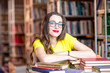 © rh2010 - Portrait of young enthusiastic female student studying with a lot of books at the library