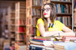 © rh2010 - Portrait of young enthusiastic female student studying with a lot of books at the library