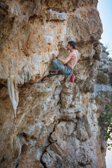 Male rock climber on challenging route on cliff