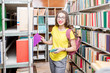 © rh2010 - Young happy and enthusiastic female student searching books on the shelves at the library