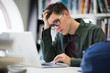 © ReeldealHD images - Student working on laptop in library