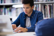 © ReeldealHD images - Student working on laptop in library
