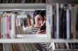 © ReeldealHD images - Student using smartphone in library