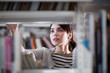 © ReeldealHD images - Student looking for a book in library