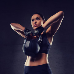 Sticker - young woman flexing muscles with kettlebell in gym