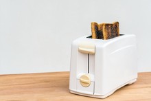 Toaster And Burnt Toasts On Wooden Table With Copyspace