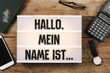 Hallo, mein Name ist..., German text for Hello, My Name is... in vintage style light box on office deskt op