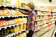 © lado2016 - Man shopping in supermarket reading product information. Checking list.