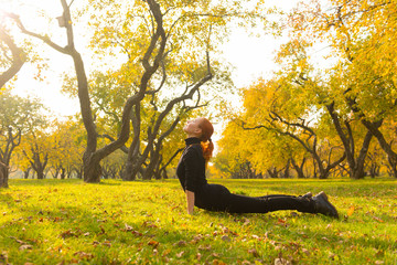 Wall Mural - Woman doing yoga in autumn park