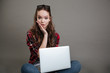 © Drobot Dean - Surprised young lady chatting by laptop computer.