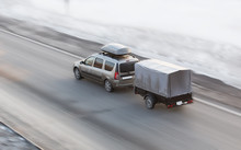 Car With Trailer Rides On The Winter Road