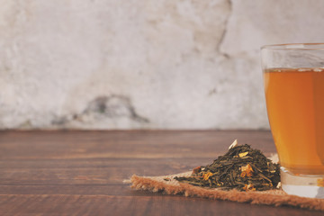 Natural green tea in a glass on the wooden brown table