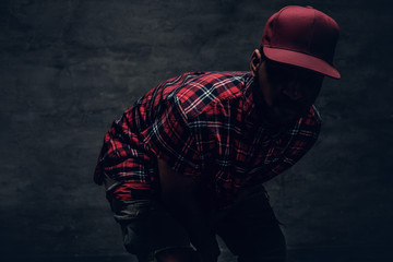 Wall Mural - A man dressed in a red fleece shirt and a cap in a shadow.