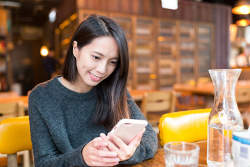 Wall Mural - Woman use of mobile phone in restaurant