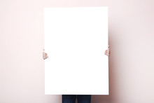 Man Holding Blank Poster On Beige Background