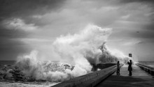 Crazy Brave People On The Pier Near The Lighthouse Make Photos During Heavy Storm Against The Backdrop Of Huge Ocean Waves. The Atlantic Coast. Douro River Mouth. Porto. Portugal. Europe.