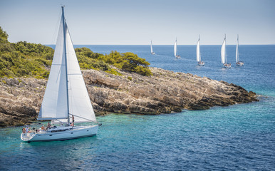 Wall Mural - White yacht sailing very close to island