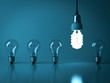© masterzphotofo - One hanging eco energy saving light bulb glowing from the unlit incandescent bulbs with reflection , stand out from the crowd , leadership and different business creative idea concept . 3D rendering.