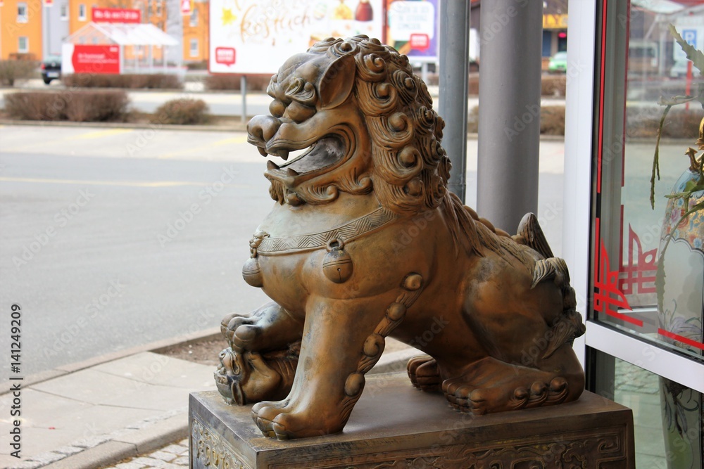 Guardian lions or Fo-dogs flank the entrance gates Buddhist temple. The ...