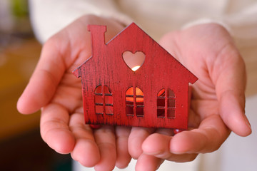 Wall Mural - Warm and cozy miniature house in female hands. Care and love.