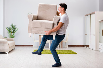 Young man moving furniture at home