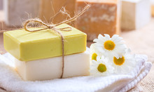 Handmade Soap Bars And Chamomile On Wooden Background