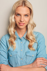 Poster - closeup of a smiling young casual woman with hands crossed