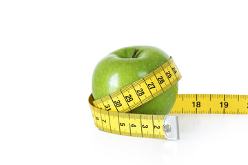 Green apple with tape measure on white background