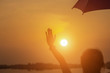 © Chittakon - Woman holding an umbrella sunset
