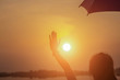 © Chittakon - Woman holding an umbrella sunset