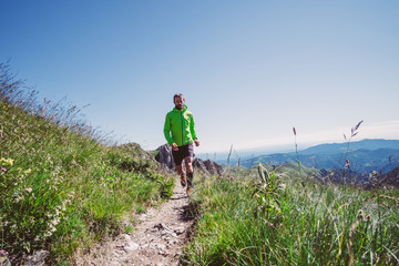 Wall Mural - man trail running on a mountain in summer