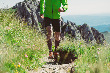 Wall Mural - Man trail running on a mountain in summer