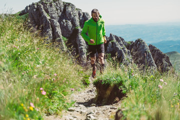 Wall Mural - man trail running on a mountain in summer