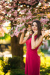 © Aleksandr - Beautiful girl posing to the photographer against the background of blooming pink trees. Spring. Sakura.