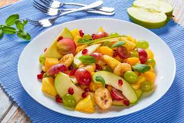 Wall Mural - colorful fruit salad with mint leaves