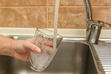 Hand holding glass of water