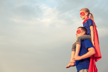 Canvas Print - Father and daughter playing superhero at the day time.