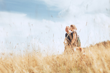 Wall Mural - two positive tourist mans walks on golden field